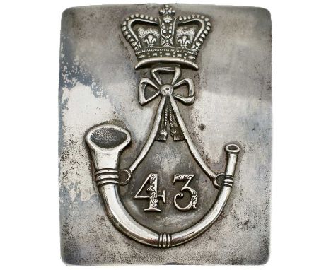 the rectangular white metal plate with 43 surrounded by a strung bugle horn and surmounted by a crown.