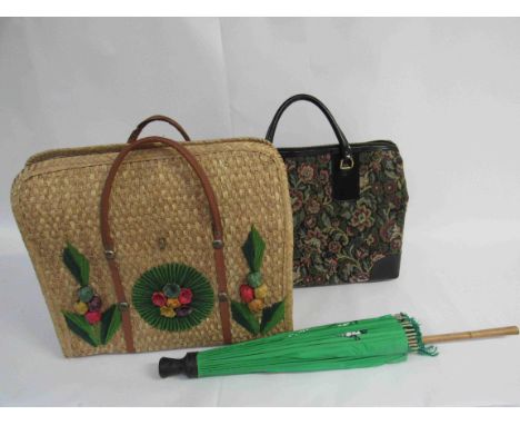 A tapestry effect holdall with hoop handles and black trim, a retro straw beach bag with applied raffia flower from Acapulco 