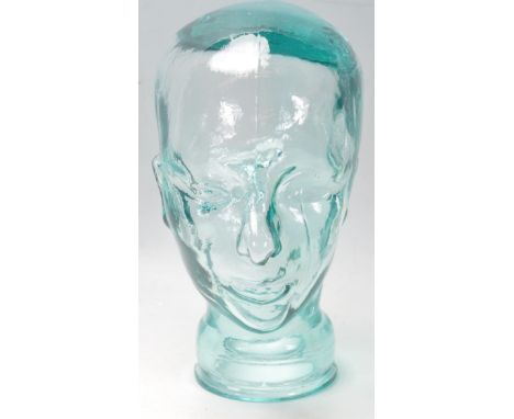 A vintage style pressed glass shop display pressed glass mannequin head with moulded details. Measures 30 cm tall. No visible