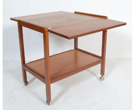 A retro vintage mid 20th century teak wood two tier drinks trolley having twin hinged leaves with banding detail raised on st