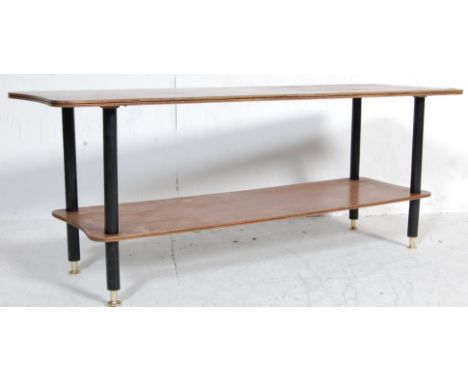 A retro vintage teak wood two tier coffee table of rectangular form raised on tapering ebonised legs united by a magazine tra