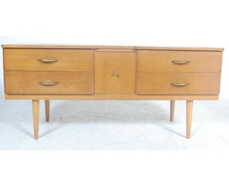 A vintage retro mid 20th century light oak veneer low sideboard credenza. The sideboard of a rectangular form having five dra