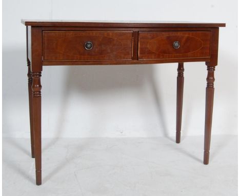 A Regency Revival antique style console table having an inlaid curved table top with two drawers to the frieze raised on tape