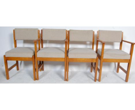 A set of four retro vintage mid 20th century teak wood dining chairs having show wood frames upholstered in white woollen fab