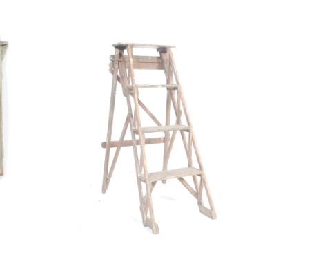 A pair of mid 20th century wooden A-frame ladders. The ladders having graduated steps and wooden frame along with a similar w