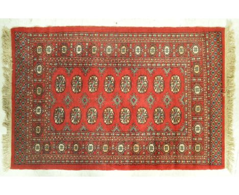 A vintage 20th Century red ground floor rug / runner having a central medallion decorated panel with geometric pattern detail