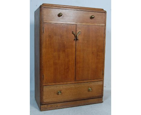 An early 20th century 1930s Art Deco style light oak tallboy chest of drawers having a raised back over a twin handled drawer