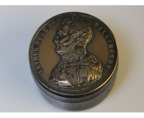 A DUKE OF WELLINGTON COMMEMORATIVE SNUFF BOX, the polished wooden snuff is topped both ends with a bronze type Duke of Wellin