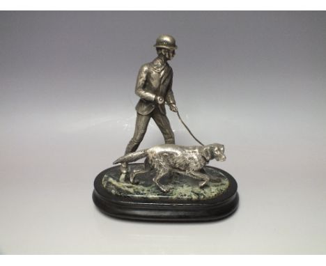 A 19TH CENTURY SILVERED BRONZE SPORTING GROUP, in the form of a beater and his hound in pursuit of game, fixed to a marbled g