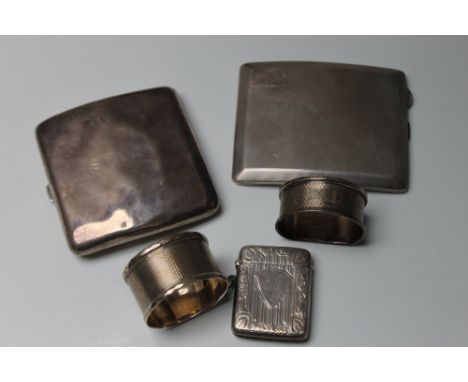 A COLLECTORS' LOT OF SILVER CONSISTING OF TWO CIGARETTE CASES, two napkin rings and a vesta case, various dates and makers, a