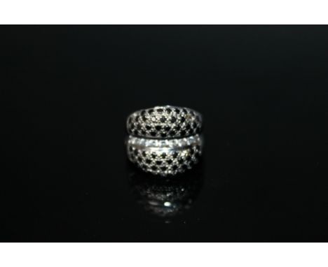 A WHITE GOLD DRESS RING, stamped 750, set with white and black stones, ring size J 