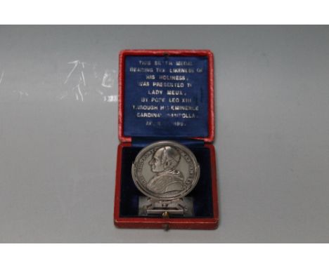 A CASED SILVER PAPAL MEDAL, coming in an embossed red Morocco case with spring action holder system and blue lining which is 