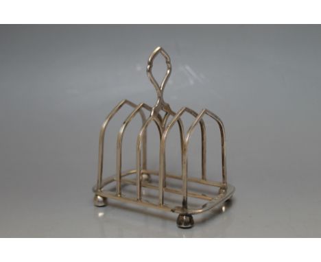 A HALLMARKED SILVER FOUR DIVISION TOAST RACK BY HENRY WILKINSON & CO - LONDON 1891,  in a Gothic style sitting on four angula