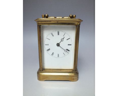 AN EARLY 20TH CENTURY BRASS CARRIAGE CLOCK, the white enamel dial with Roman numerals, carry handle, H 17 cm