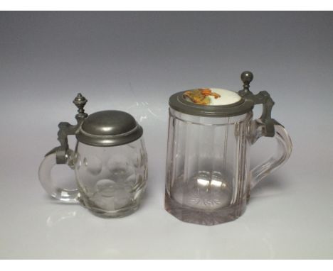 TWO 19TH CENTURY PEWTER MOUNTED BOHEMIAN GLASS TANKARDS, the larger example with inset ceramic panel depicting a galloping ho