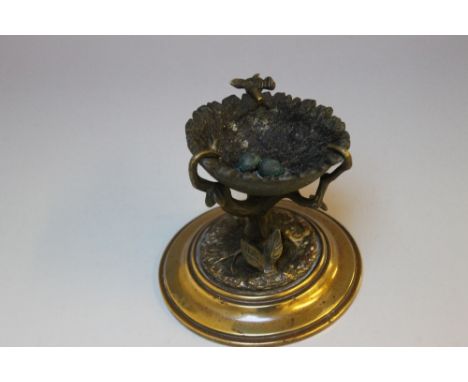 AN UNUSUAL BRONZE MODEL OF A BIRDS NEST, set within the branches of a tree and containing two eggs, on a brass stepped base, 
