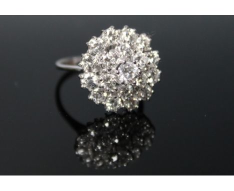 A DIAMOND CLUSTER RING, having a triple layer of good colour diamonds the central being of approx. 0.50 carat, the ring total