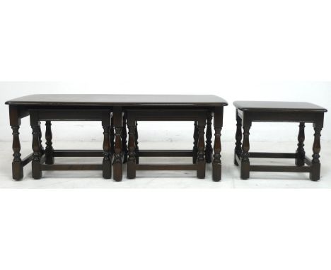 An Ercol dark stained oak coffee table, 'Nest of Trinity Tables', model 732/3, circa 1980, 114.5 by 49.5 by 41cm high, includ