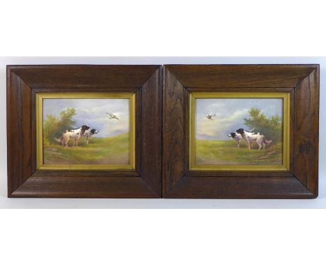 A pair of Edwardian Crown Devon Fieldings painted ceramic plaques, by R. Hinton, each depicting two spaniel gun dogs looking 