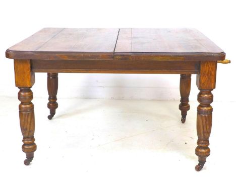 A late Victorian oak extending dining table, with two additional leaves, 29cm and 30cm, carved baluster legs and brown cerami