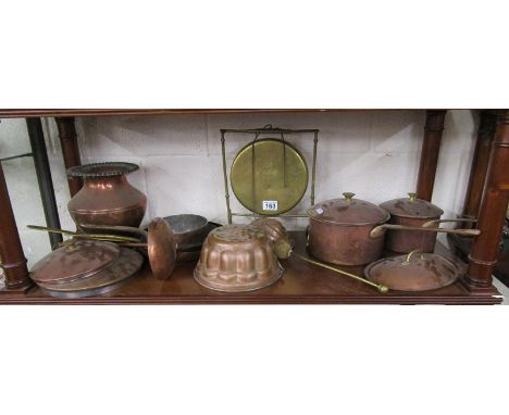 Shelf of metalware, mostly copper and a brass gong