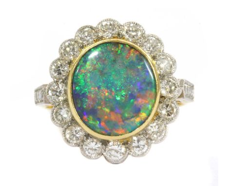 A gold boulder opal and diamond cluster ring, an oval boulder opal, rub set in yellow gold, to a surround of brilliant cut di