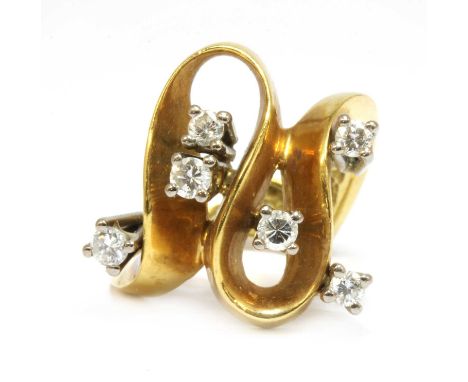 A gold diamond set wave head ring, c.1970, with a looped flat wire head and scattered brilliant cut diamonds, all four claw s