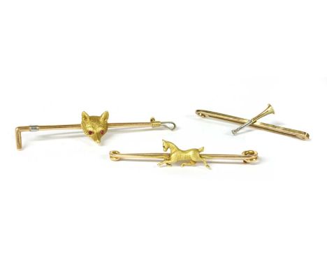 A group of gold equestrian brooches, to include a fox head with cabochon ruby eyes, marked 18ct, applied to the centre of a r