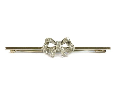 A white gold diamond set bow brooch, c.1925, an open ribbon bow, milligrain set with lines of eight cut diamonds, to a flat s