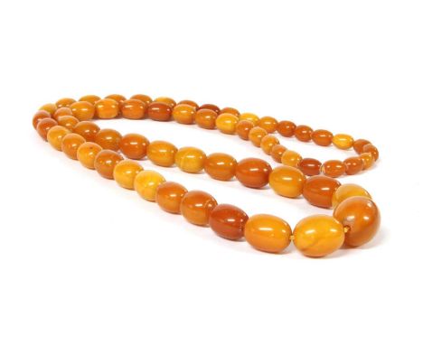 A continuous single row graduated olive-shaped butterscotch amber bead necklace, fifty-nine beads, approximately 26.0 x 20.0m
