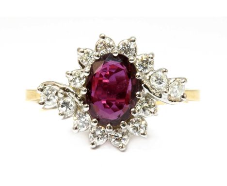 An 18ct gold ruby and diamond crossover cluster ring, an oval mixed cut ruby, claw set to the centre, to a border of brillian