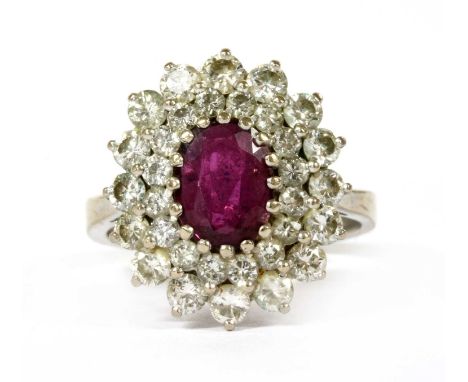 A white gold ruby and diamond cluster ring, an oval mixed cut ruby, to a stepped two-tier surround of brilliant cut diamonds.