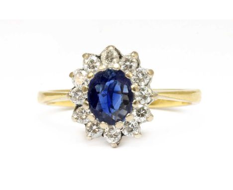 An 18ct gold sapphire and diamond oval cluster ring, an oval mixed cut sapphire with a surround of brilliant cut diamonds, cl