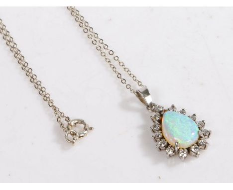 A silver opal and paste pendant and necklace, the pendant set with a pear shaped opal surrounded by paste set on a silver cha