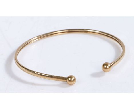 A 9 carat gold bangle with orb finials, hallmarked for Birmingham, weight 2.6 grams&nbsp;