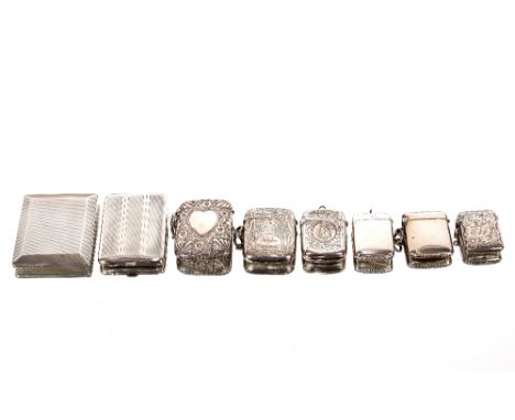 A silver match booklet holder, with engine turned decoration, Chester 1928; a smaller similar; and six various silver vesta c