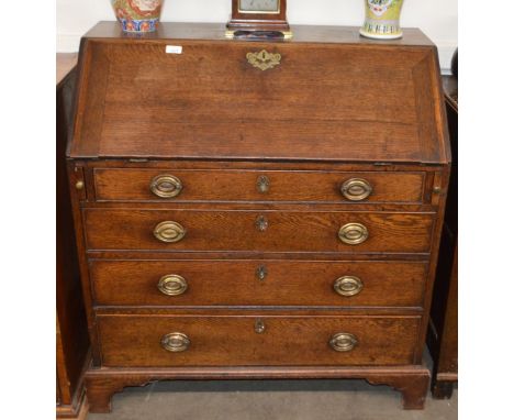 A Georgian oak bureau, the fall front opening to reveal an interior of drawers and pigeon holes around a central cupboard, fo