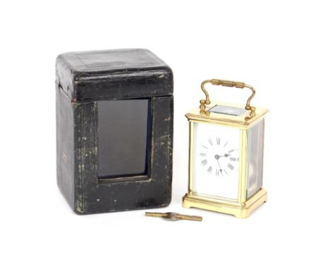 A brass cased carriage timepiece, white enamel Roman numeral dial, turned swing handle, 14.5cm high with handle extended, con