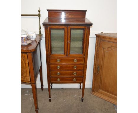 An Edwardian mahogany inlaid and chequer banded display / music cabinet, the display shelf enclosed by a pair of glazed panel