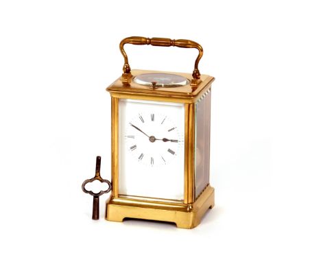 A brass cased striking carriage clock, having repeat button, bevelled glass, angular swing handle, 16cm high with handle rais