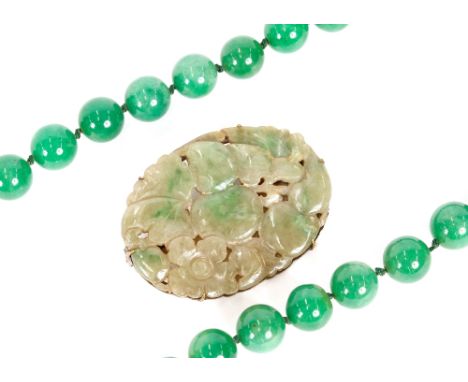 A vintage Chinese jade and white metal clip, carved with fruit and flowers; and a string of green jade beads 