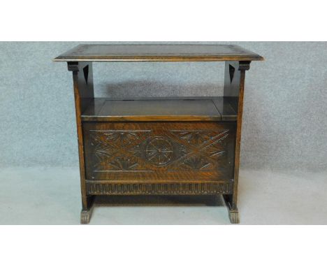 A 20th century oak monk's bench with sliding back and top on carved panel base. H.70 W.77 D.46cm 