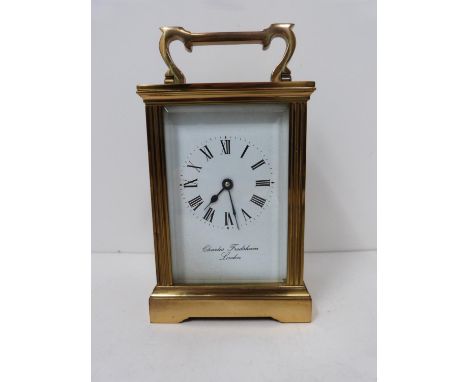 A 20th century brass carriage clock by Charles Frodsham, London, with bevelled glass sides and white enamel dial with black r