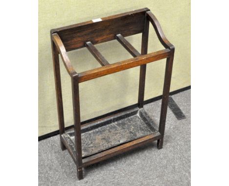 An Edwardian oak stick stand, with three compartments above a metal tray, within rectangular section frame, 68.5 cm high x 46