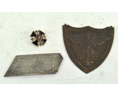 A Polish metal plaque in the form of a shield, dated 1912/20; together with an enamel screw badge and another plaque