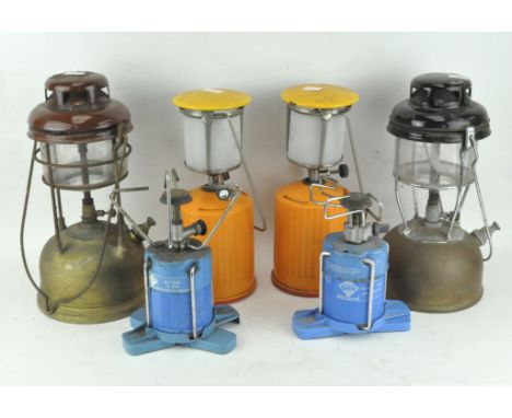 A collection of assorted lanterns, including an enamel Tilley lamp and camping stoves