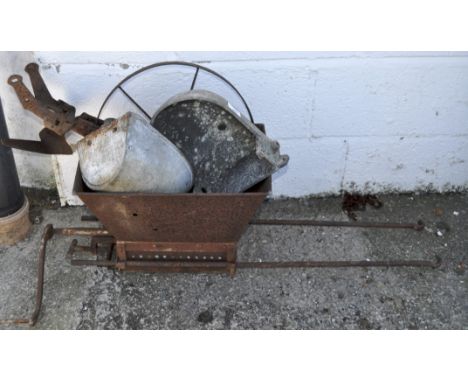 A collection of various metal farming items, including a feeding trough and other items