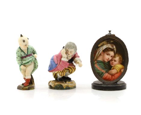 A Jacob Petit porcelain figure of a man relieving himself, 19th century, crouching and struggling with a golden nugget, 9cm h