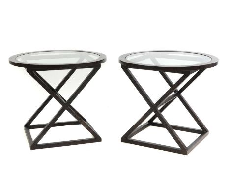 A pair of modern circular occasional tables by Andrew Martin, plate glass tops, on stained wood X-framed bases70cm diameter60