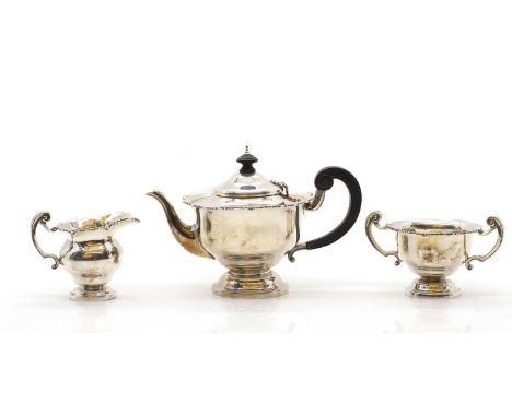 A silver three-piece tea service to include a teapot, 22cm wide, a cream jug, 9cm high, and a twin-handled sugar bowl, 13.5cm